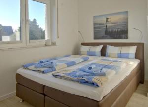 ヴァンガーオーゲにあるMittelpunkt 9 - Zentrales Reihenhaus in perfekter Lageの大型ベッド(青と白のタオル付)