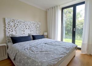 ヴァンガーオーゲにあるWellenklang - Luxusbungalow mit Rosengartenのベッドルーム(大型ベッド1台、大きな窓付)