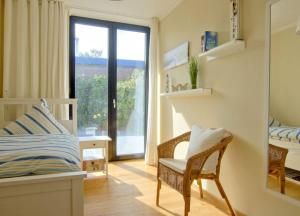 ヴァンガーオーゲにあるWellenklang - Luxusbungalow mit Rosengartenのベッドルーム1室(ベッド1台、景色を望む窓付)
