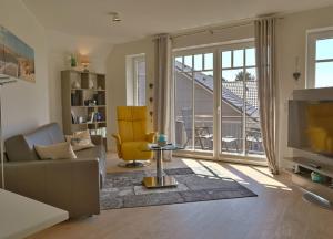 ein Wohnzimmer mit einem Sofa und einem TV in der Unterkunft Skipper - Apartment mit Stil an den Dünen in Wangerooge