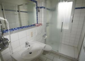 ヴァンガーオーゲにあるFerienwohnung 6 Rosenrotの白いバスルーム(シンク、シャワー付)