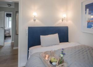a bed with a blue headboard with a tray of fruit on it at Traumwooge - Traumferien mit Luxus in Wangerooge