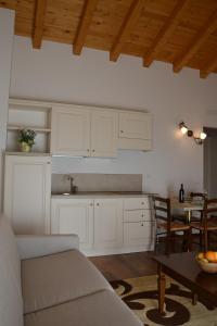 a kitchen with white cabinets and a table with a couch at Agriturismo Gradec in Aurisina