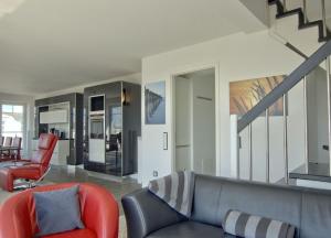 ヴァンガーオーゲにあるWoogeDiva - die höchste Wohnung Wangeroogesのリビングルーム(ソファ、階段付)