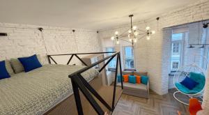 1 dormitorio con 1 cama y una escalera con una lámpara de araña. en Квартира-студія в центрі міста біля Ратуші, en Chernivtsi