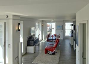 ヴァンガーオーゲにあるWoogeDiva - die höchste Wohnung Wangeroogesのリビングルーム(テーブル、赤い椅子付)