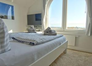 ヴァンガーオーゲにあるWoogeDiva - die höchste Wohnung Wangeroogesのベッドルーム1室(ベッド2台、大きな窓付)