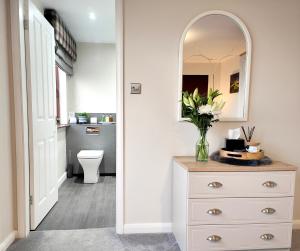 a bathroom with a white dresser and a mirror at Yewtree House in Penrith +53 photos