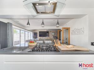 a kitchen with a stove top oven in a room at Host Liverpool - Greasby Luxury Home, Near Golf & Beach in Greasby