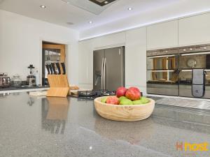 a kitchen with a bowl of apples on a counter at Host Liverpool - Greasby Luxury Home, Near Golf & Beach in Greasby