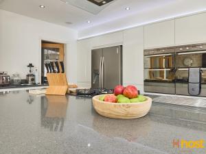 una cocina con un tazón de manzanas en una encimera en Host Liverpool - Greasby Luxury Home, Near Golf & Beach, en Greasby