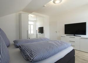 two beds in a room with a flat screen tv at WoogeElisa - Ehrwürdige Dorfvilla in Strandnähe in Wangerooge