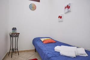 Un dormitorio con una cama azul y un reloj en la pared en Sweet Home Rosa, en Marsala