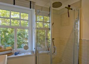 a bathroom with a glass shower with a window at Linnenboom - lichtdurchflutete Neubauwohnung für gehobene Ansprüche in Wangerooge +16 photos