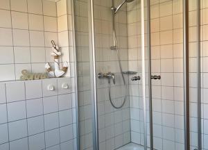 a bathroom with a shower with a glass door at Sonnenstern - Sonnenverwöhnte Familienwohnung mit Balkon in Wangerooge +13 photos