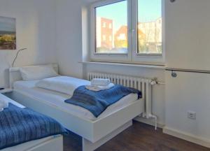 ヴァンガーオーゲにあるRobby 6 - Strandnahe, ruhige Ferienwohnung mit Balkonの小さなベッドルーム(ベッド1台、窓付)