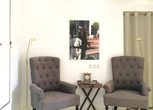 two chairs and a table with a picture on the wall at Robby 7 - Hundefreundliche Terrassenwohnung mit eigenem Garten in Wangerooge