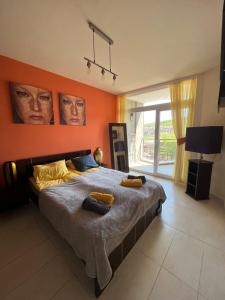 a bedroom with a large bed with orange walls at Bułgaria na lato apartament z widokiem na morze Sozopol in Sozopol