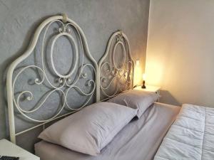 1 cama con cabecero de metal en un dormitorio en LamaDue - Casa Vacanze en Borra