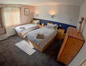 a small room with two beds and a window at Allandale House in Brodick