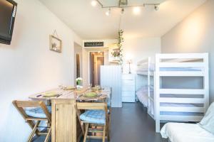 a dining room with a table and chairs and a bunk bed at Le Freeride - 14ème étage avec vue sur montagne in Villarembert