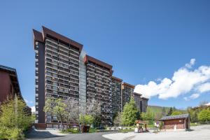 a large apartment building in the middle of a street at Le Freeride - 14ème étage avec vue sur montagne in Villarembert