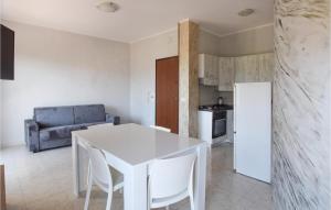 Marina di StrongoliにあるNice Apartment In Marina Di Strongoli With 2 Bedrooms And Wifiのキッチン(白いテーブル、椅子付)