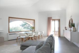a living room with a couch and a table and chairs at Villa Allegra Luxury Holiday House in Salò