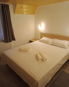 um quarto com uma cama branca com duas toalhas em Casa Iulia & Matei em Cîrţişoara