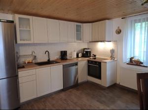 科希夏拉的住宿－Casa Iulia & Matei，厨房配有白色橱柜、水槽和冰箱。