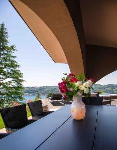 a vase with flowers on a table on a patio at Villa Allegra Luxury Holiday House in Salò +23 photos