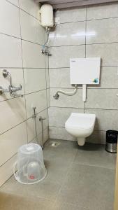 a bathroom with a toilet and a phone on the wall at Casa Cabin Stay Mumbai in Mumbai