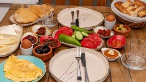 een houten tafel met borden en schalen van voedsel bij Avlu Alaçatı Boutique Hotel in Alacati