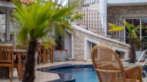 a patio with a table and chairs and a pool at Avlu Alaçatı Boutique Hotel in Alaçatı