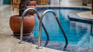 una piscina con dos barras de metal junto al agua en Avlu Alaçatı Boutique Hotel en Alacati