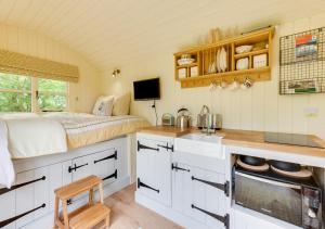 a kitchen with a bed in a small room at The Orchards Retreat Shepherds Hut in Saint James