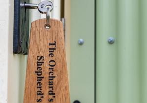 a wooden key tag hanging on a door at The Orchards Retreat Shepherds Hut in Saint James