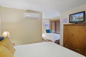 a hotel room with two beds and a flat screen tv at Bear Claw 312 - Ski-in Ski-out Condo! in Steamboat Springs