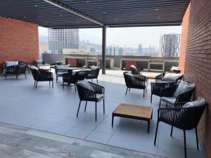 un patio con sillas y mesas en un edificio en Departamento nuevo en Centro Cuauhtémoc, en Monterrey