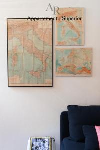 a map hanging on a wall next to a couch at Appartamenti Ridolfi in Empoli