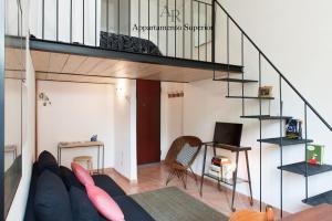 a living room with a couch and a spiral staircase at Appartamenti Ridolfi in Empoli