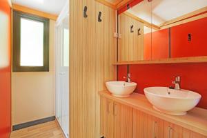 a bathroom with two sinks on a wooden counter at CityKamp Angers in Angers