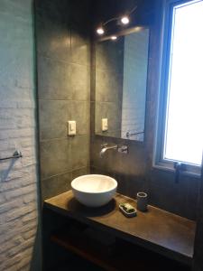 a bathroom with a sink and a mirror on a counter at Miralejos in Punta Del Diablo