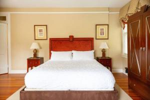a bedroom with a large white bed with two night stands at Relaxed Studio close to Duke & Downtown Durham in Durham