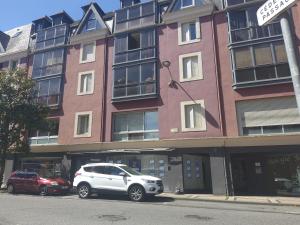 a white car parked in front of a building at Apartamento Agradable in Tarbes