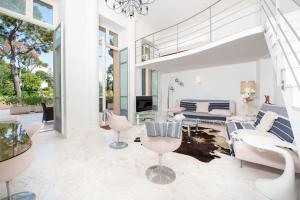 een woonkamer met witte meubels en grote ramen bij Luxurious Historical Suite 2BDR Pool Tennis Private Beach in Roquebrune-Cap-Martin