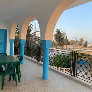 einen Balkon mit einem Tisch und Stühlen sowie Meerblick in der Unterkunft Dar El Ferdaous in Zarzis