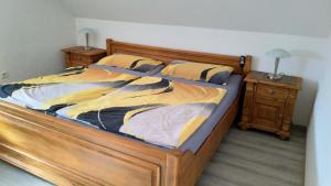 1 cama grande en un dormitorio con marco de madera en Ferienwohnung Wanderlust en Bad Berleburg