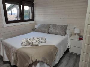 a bedroom with a bed and a window at O Refuxo in Rosal