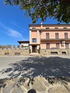 duży ceglany budynek z drzewem przed nim w obiekcie Da Nonna Nina Casa Vacanza w mieście Acciaroli